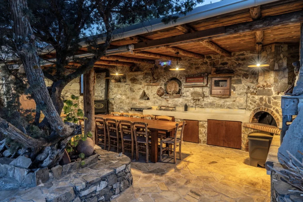Covered outdoor BBQ and long dining table at Vorénia Horizon, South Crete
