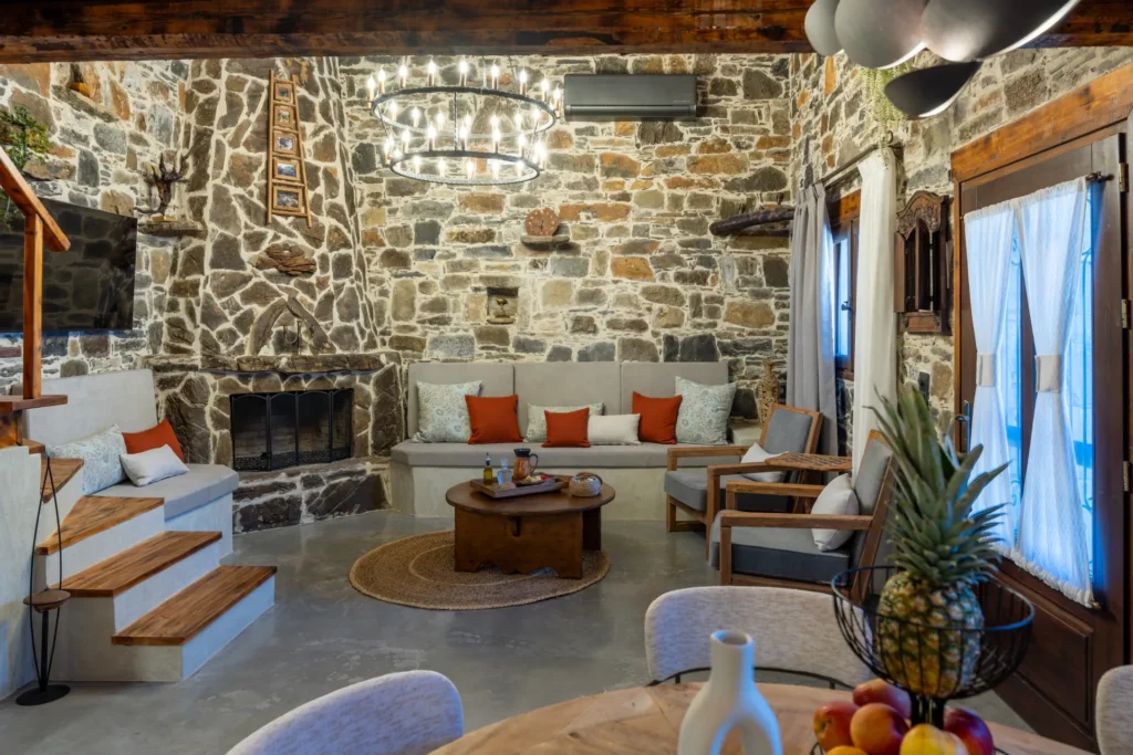 Stone-walled living room with fireplace at Vorénia Horizon, South Crete