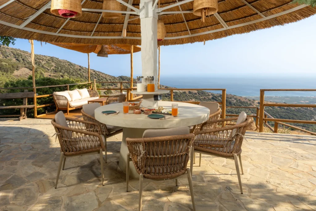 Shaded outdoor lounge and dining terrace at Vorénia Horizon, South Crete
